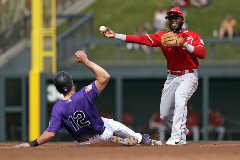 Los Angeles Angels second baseman Luis Rengifo, right, throws to first after forcing out Colorado Rockies' Mark Reynolds at second base in the second inning of a spring training baseball game Wednesday, March 6, 2019, in Scottsdale, Ariz. Rockies' Pat Valaika was safe at first on the fielder's choice play. (AP Photo/Elaine Thompson)