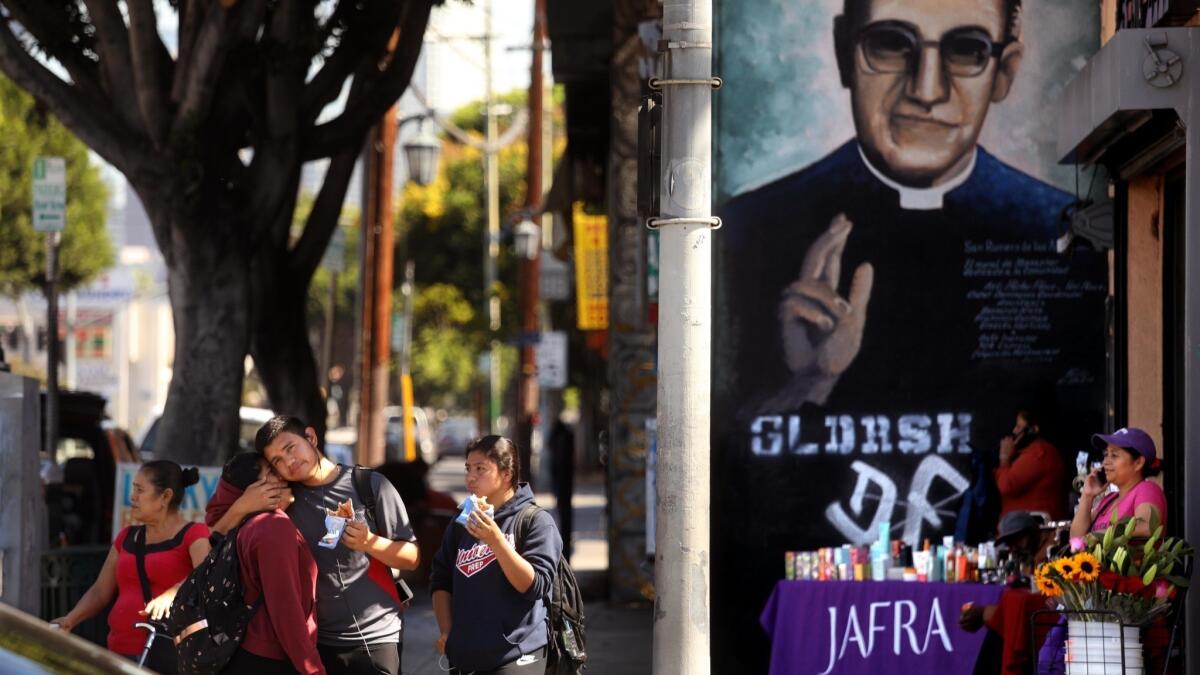 A mural of Oscar Romero seems to bless pedestrians who wait to cross the street on Pico Boulevard.