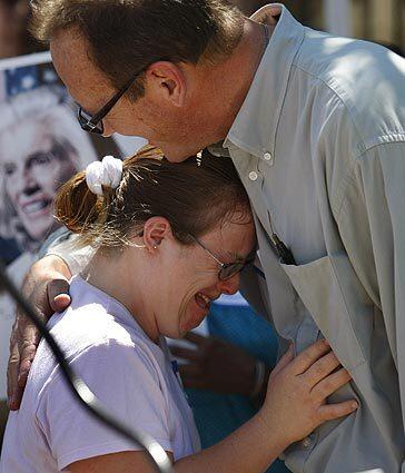 Lily Hixon, 25, a developmentally disabled resident of Regency Court, hugs her father, Ken Hixon, and cries during a news conference to protest the termination of leases for about 20 tenants under age 62.