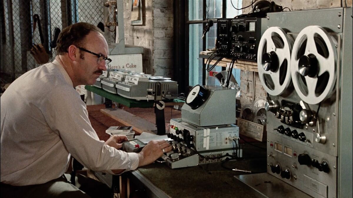 A man operating reel-to-reel sound equipment in the movie “The Conversation.”