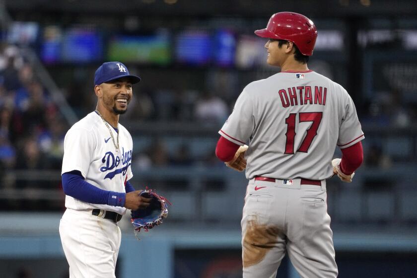 Dodgers second baseman Mookie Betts chats with Angels two-way star Shohei Ohtani on the field