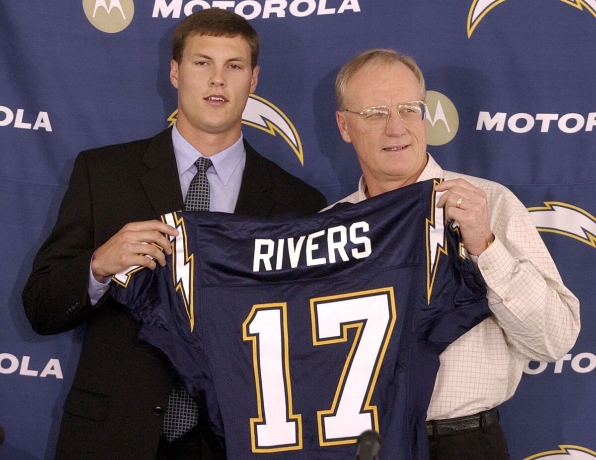 Philip Rivers holds up his Chargers jersey with coach Marty Schottenheimer in 2004.