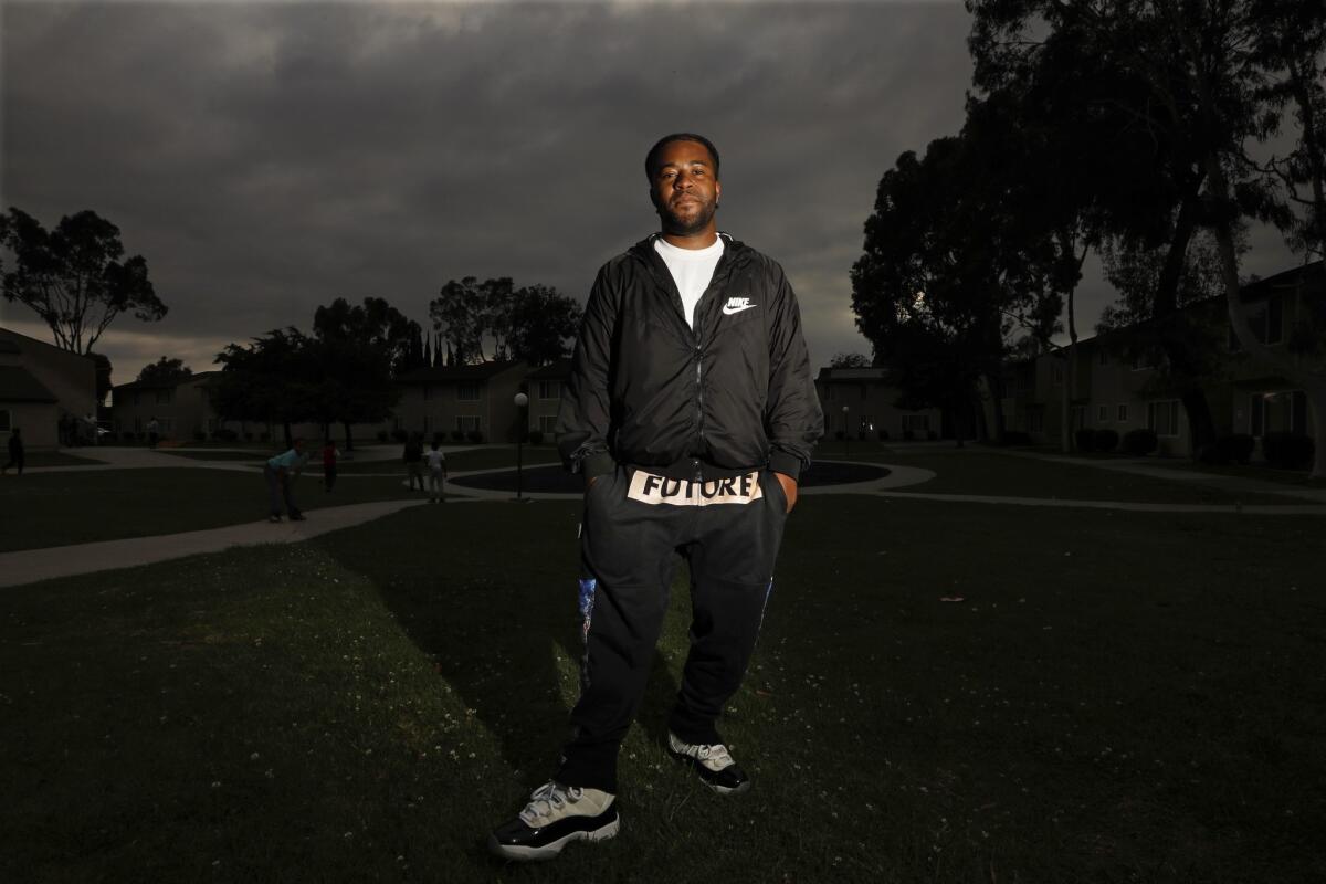 Laurence " Boogalue" Cartwright, 30, a former gang member with the Campanella Park Pirus, revisits the Warwick Terrace Apartments where he grew up in Compton. (Genaro Molina / Los Angeles Times)