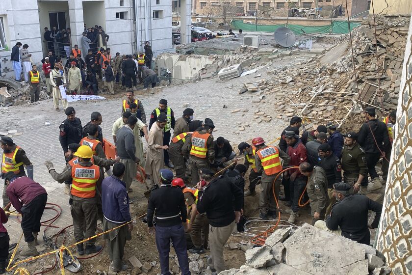 Agentes de seguridad y rescatistas buscan cuerpos en el lugar de un ataque suicida en Peshawar, Pakistán, el lunes 30 de enero de 2023. Decenas de personas murieron y más de un centenar resultaron heridas en la explosión en una mezquita. (AP Foto/Zubair Khan)