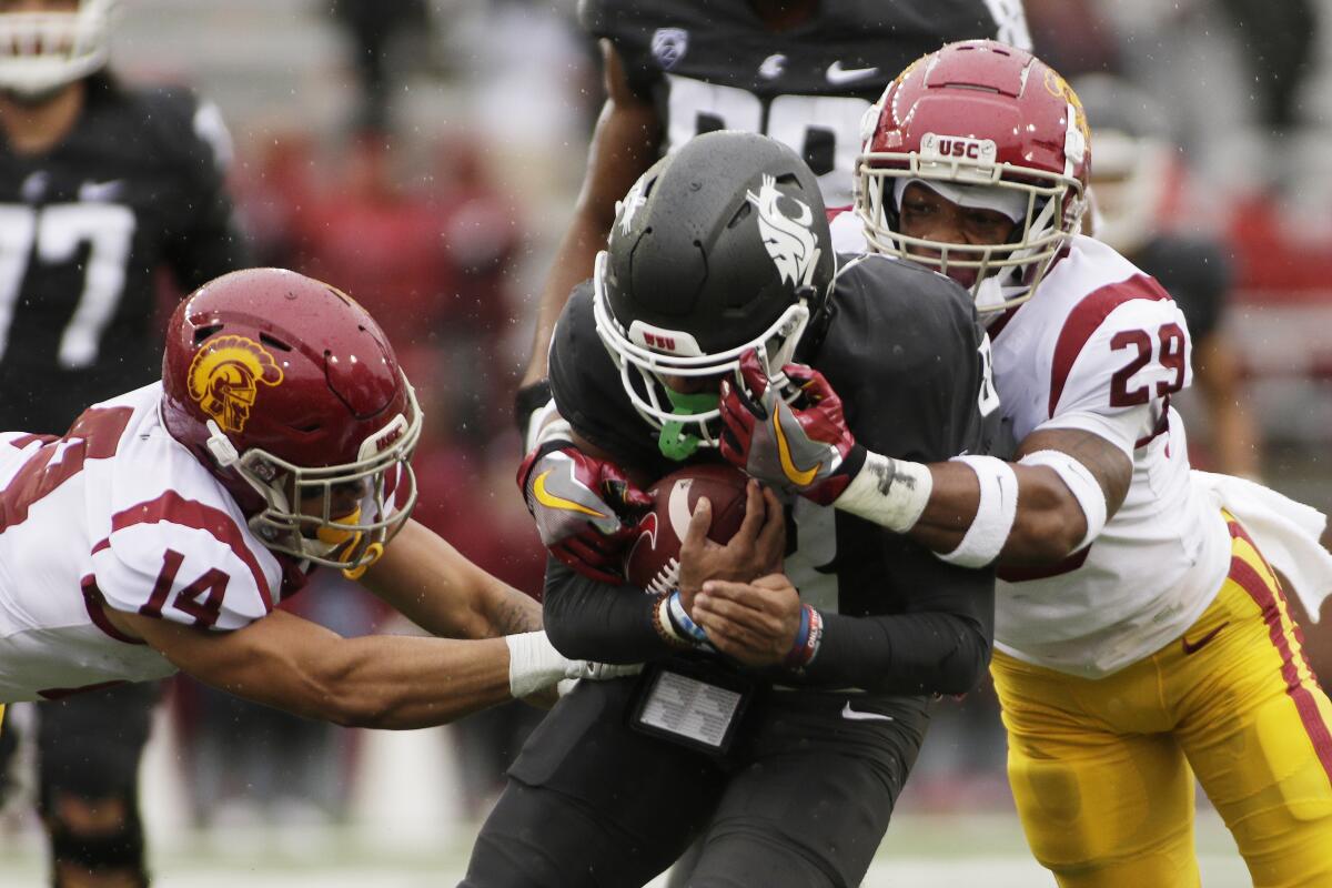 USC cornerback Jayden Williams and safety Xavion Alford tackle Washington State wide receiver Calvin Jackson Jr.