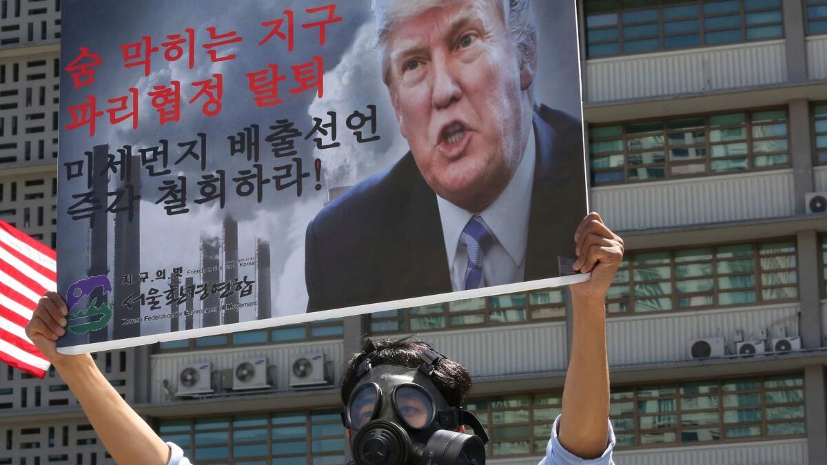 A South Korean environmental activist wearing a gas mask participates in a protest denouncing the U.S. withdrawal from the Paris Agreement.