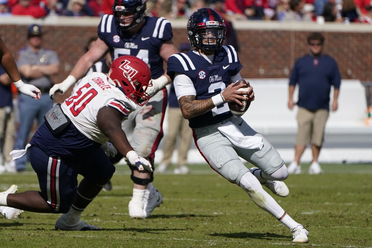 Mississippi quarterback Matt Corral (2) escapes a tackle attempt by Liberty defensive tackle Henry Chibueze (50) during the second half of an NCAA college football game in Oxford, Miss., Saturday, Nov. 6, 2021. Mississippi won 27-14. (AP Photo/Rogelio V. Solis)