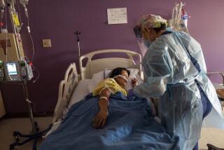 LOS ANGELES, CA - AUGUST 13: Carolyn Tan, RN, right, checks on her covid19 positive patient Socorro Carrillo, 58, left, inside the covid unit at White Memorial Hospital on Friday, Aug. 13, 2021 in Los Angeles, CA. The nurse is helping her patient move from her back to her side. Today the hospital reported they have 21 covid19 positive patients. (Francine Orr / Los Angeles Times)