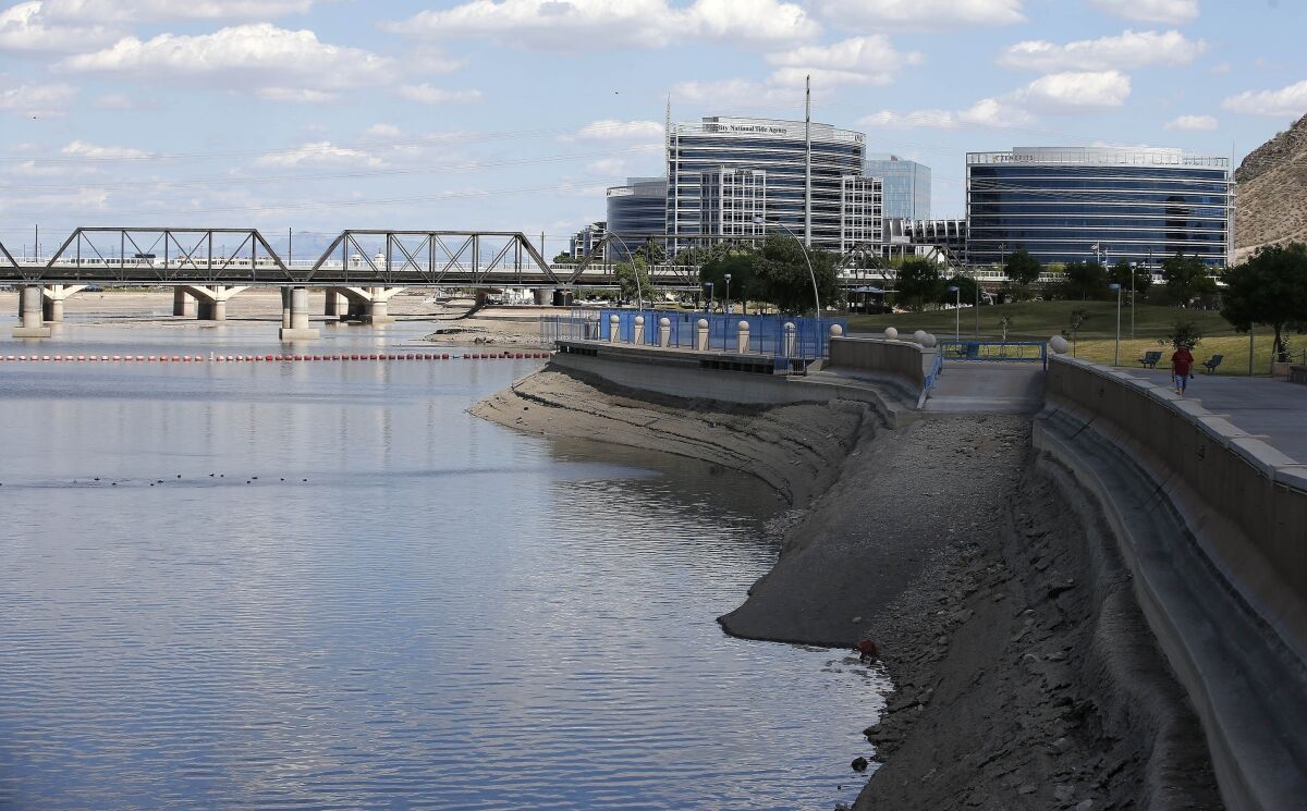 FILE - The slow process of refilling Tempe Town Lake takes place after a new dam was built to replace the previously damaged dam, on April 12, 2016, in Tempe, Ariz. The Phoenix suburb is reviewing how to handle water rescues as video of three police officers appearing to do nothing as a homeless man drowns continues to draw outcry. The Tempe Police Department says the three officers are on administrative paid leave after last month's drowning in the man-made city lake. (AP Photo/Ross D. Franklin, File)