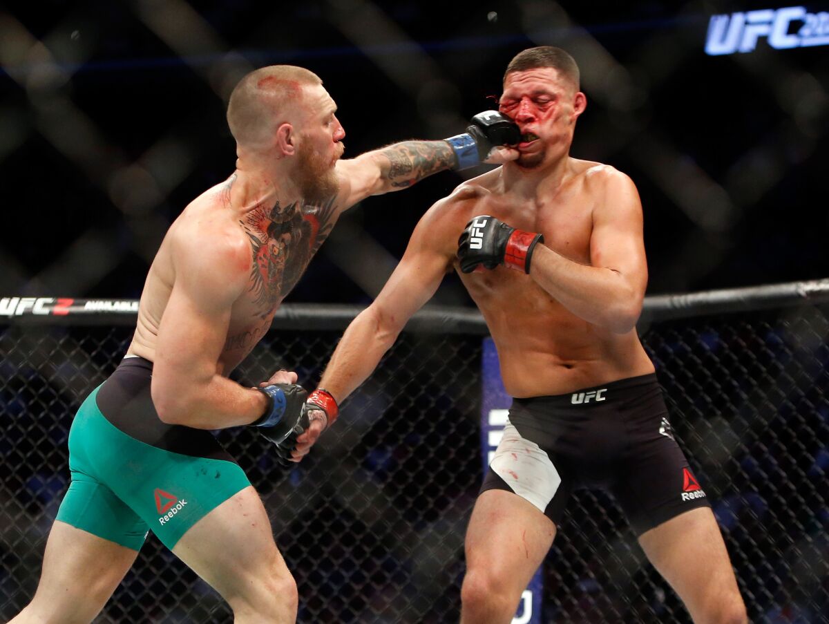Conor McGregor lands a left to the face of Nate Diaz during their welterweight rematch at UFC 202.