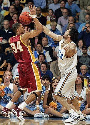 Trojan guard Gabe Pruitt fights for control of the ball against UCLA point guard Jordan Farmer.