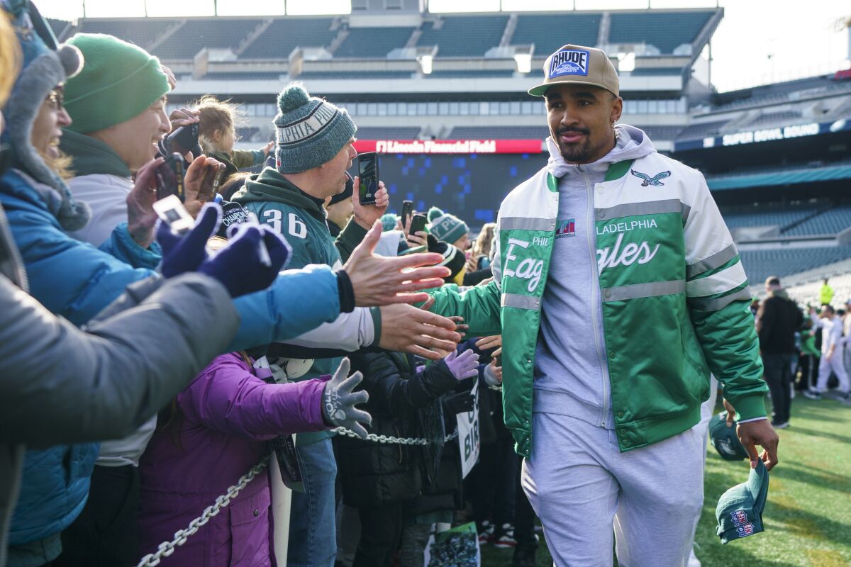Eagles quarterback Jalen Hurts interacts with fans on his way to the stage