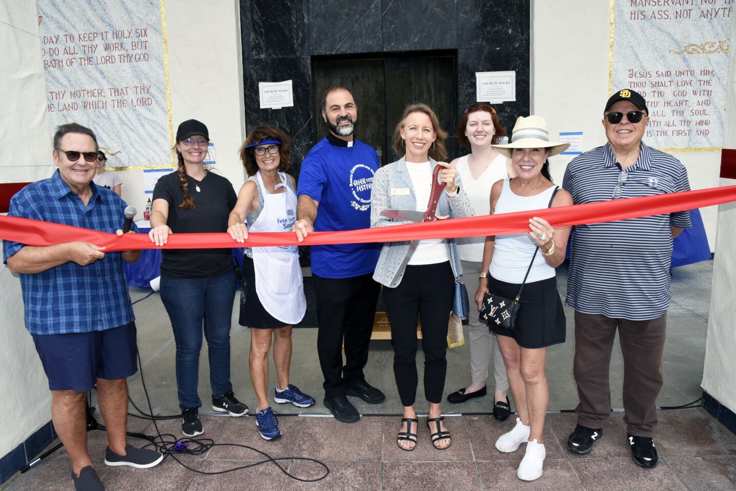 Parish Council President Spiro Kailas, Event co-chairs Kristina Flynn and Linda van Kounelis, Saints Constantine and Helen Greek Orthodox Church Reverend Father Angelo Maginas, Encinitas Mayor Catherine Blakespear, Mariah Kallhoff (representing State Assembly District 76 Representative Tasha Boerner Horvath), Jeannie and Gerry Ranglas at the ribbon cutting to open the Cardiff Greek Festival