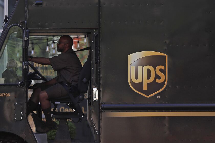 A United Parcel Service driver stops at a traffic light inside a UPS delivery van Friday, April 24, 2020, in St. Louis. (AP Photo/Jeff Roberson)