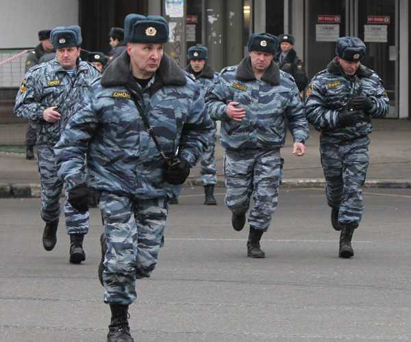 Russian riot police run near the Lubyank Station