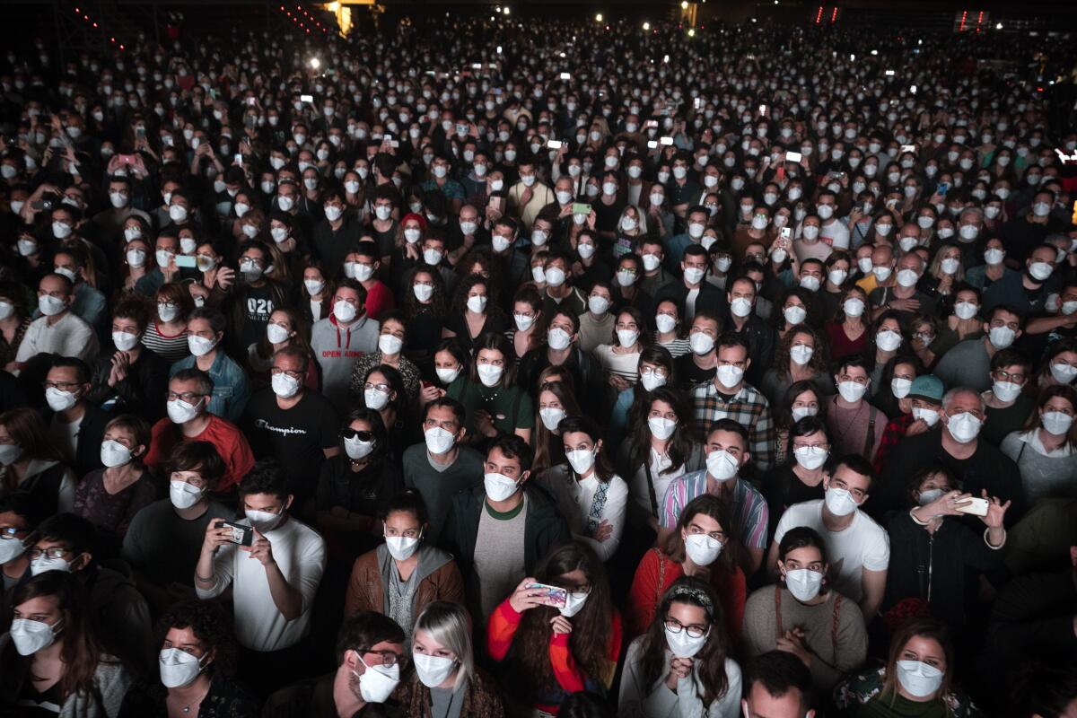 FILE - People using face masks attend a music concert in Barcelona, Spain, March 27, 2021. With one of Europe's highest vaccination rates and its most pandemic-battered economies, the Spanish government is laying the groundwork to approach the virus in much the same way countries deal with flu or measles. (AP Photo/Emilio Morenatti, File)