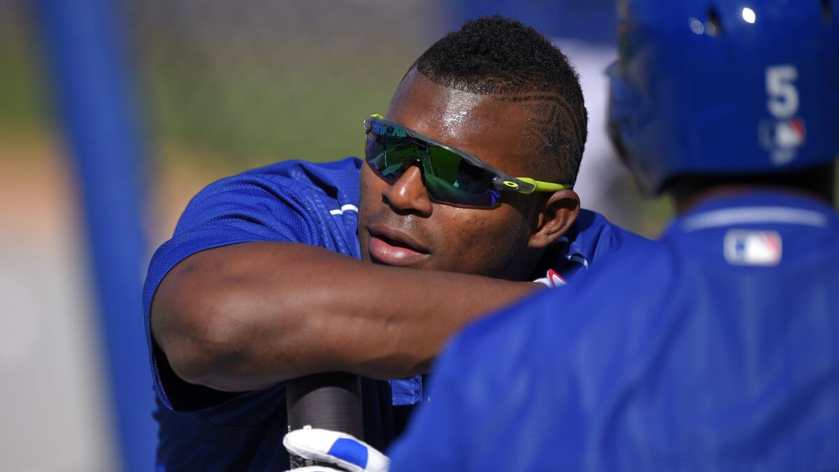 Dodgers right fielder Yasiel Puig speaks with teammate Alberto Callaspo before a game against the San Francisco Giants on Friday.