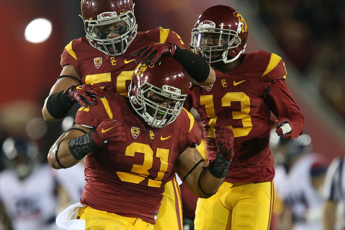 USC fullback Soma Vainuku (31) celebrates with teammates after making a tackle on Arizona punt returner Nate Phillips in the first half.