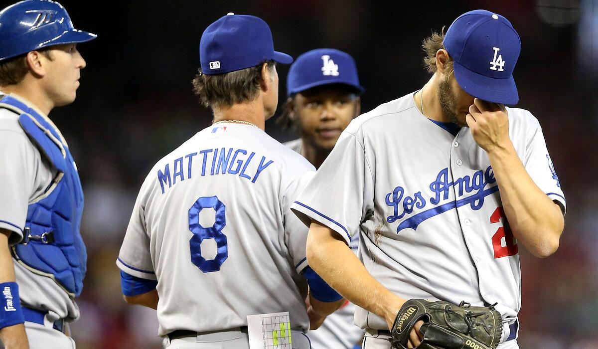 Dodgers ace Clayton Kershaw leaves the mound after Manager Don Mattingly came to replace him in the second inning Saturday in Phoenix.
