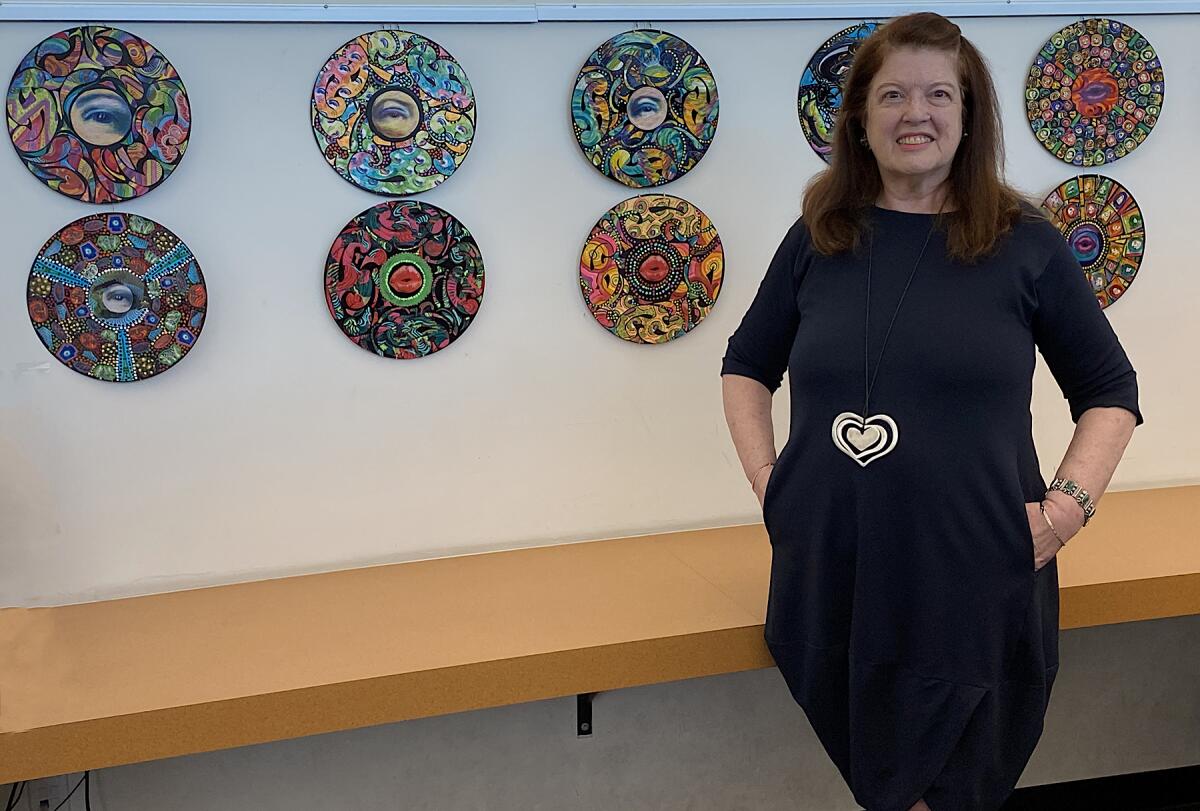 Artist Patricia Frischer at her wall of records.