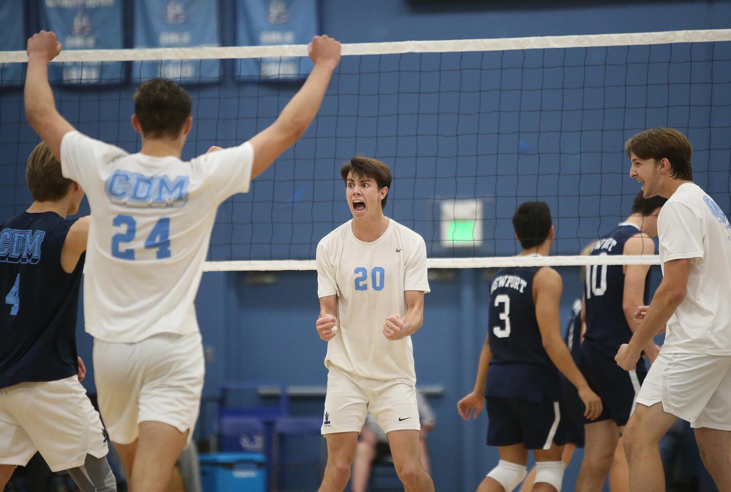 Corona Del Mar's Conner Zylstra (4) Shane Premer (24) and Adam Flood (20) celebrate winning game one during Battle of the Bay boys' volleyball match in Surf League play on Wednesday.