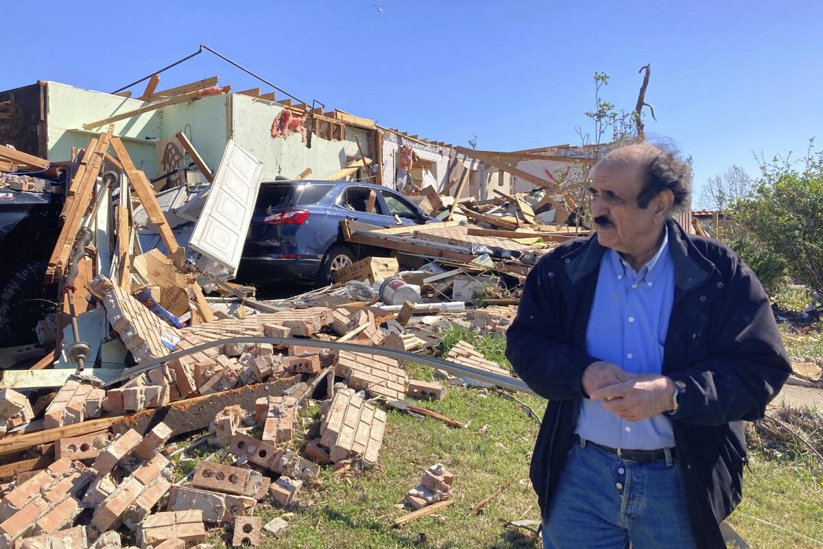 Masoud Shahed-Ghaznavi stands in front of the remains of his home. 