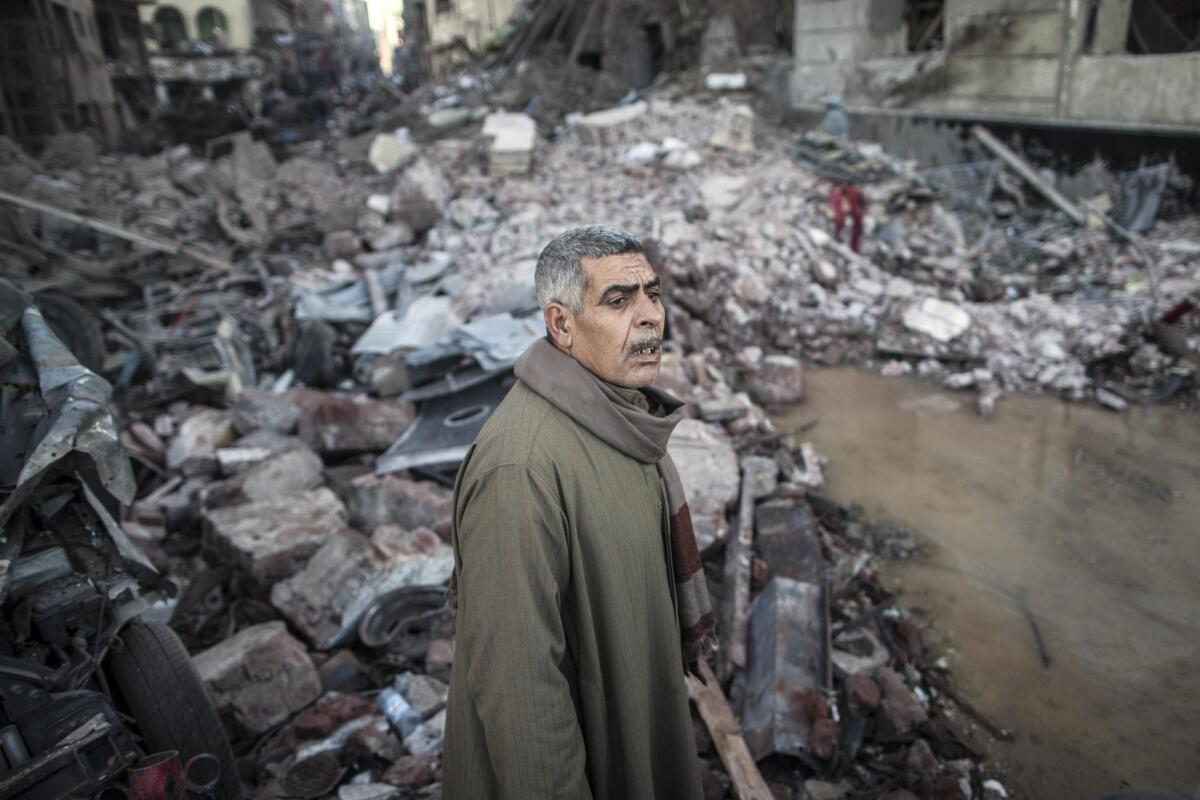 An Egyptian man stands amid debris at the site of a powerful car bomb explosion in the Egyptian city of Mansoura.