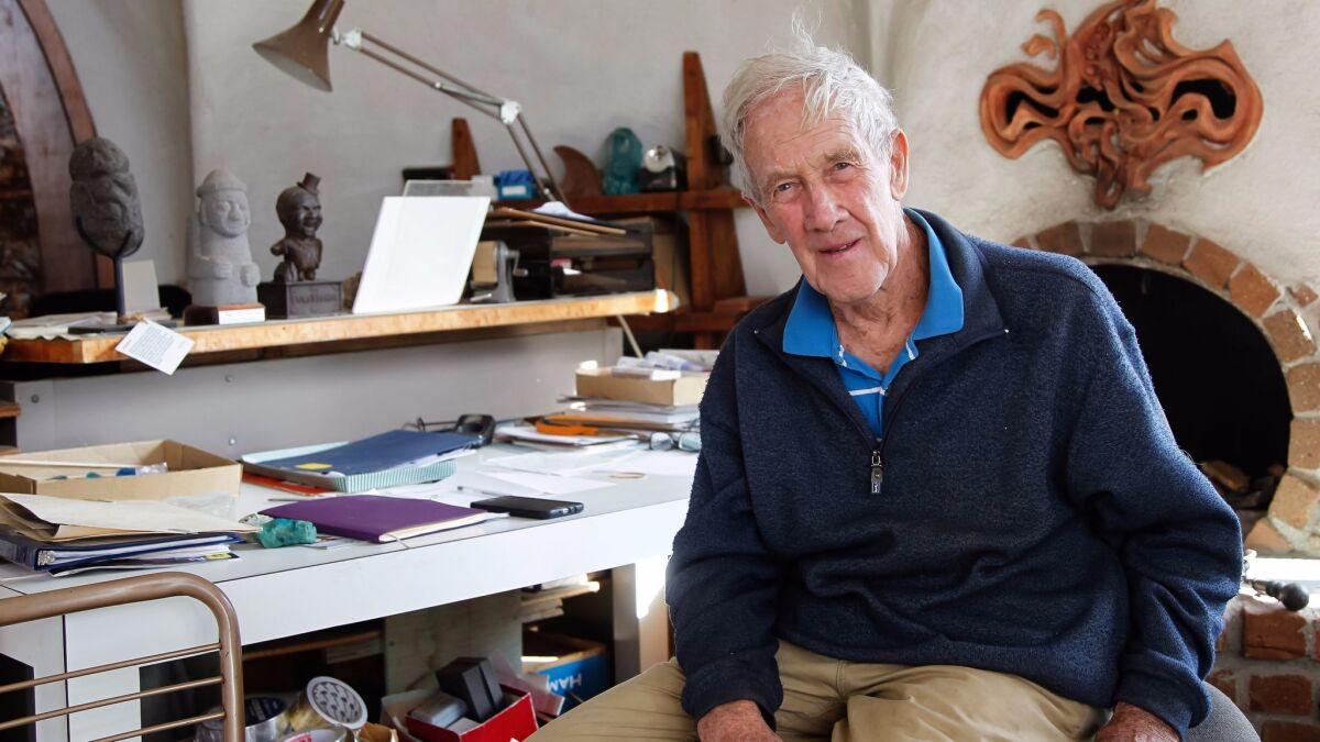 Artist, designer and San Diego icon James Hubbell sits at his desk at his home in Santa Ysabel on Wednesday.