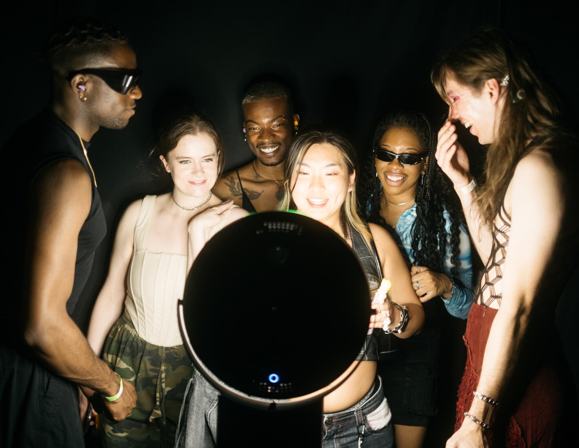 A group of people takes a group portrait in a photo booth.