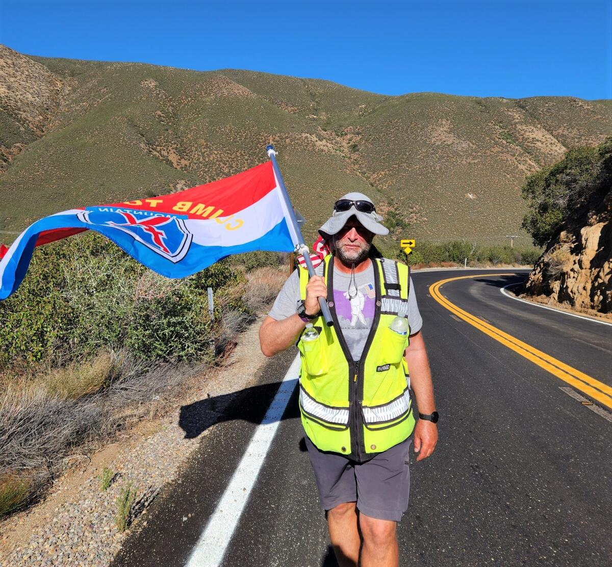 Kenny Mintz walked up Banner Grade toward Julian with a flag honoring his U.S. Army infantry battalion in Afghanistan in 2011