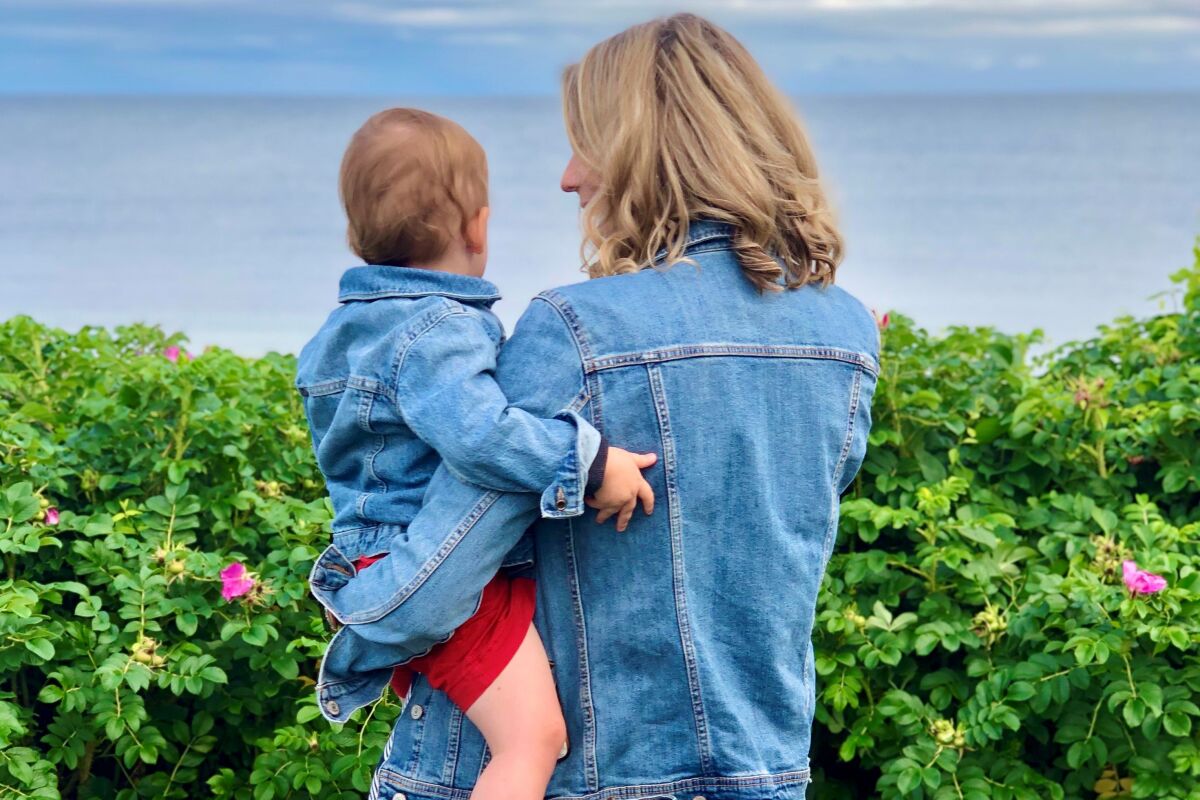 This photo provided by Alex Richer shows his wife, AP writer Alanna Durkin Richer, holding one of their children at Massachusetts' Cape Cod on July 4, 2021. In the aftermath of the May 2022 Uvalde, Texas, school shooting, she writes, "I know rationally that I can’t keep my almost 3-year-old son and his 7-month-old sister in a bubble all their lives. No matter how hard I try, I won't always be able to protect them from harm and pain. But why should I have to fear simply sending them to school?" (Alex Richer via AP)