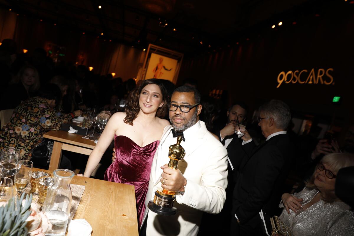 Jordan Peele with his newly engraved Oscar and wife Chelsea Peretti at the 90th Academy Awards Governors Ball.