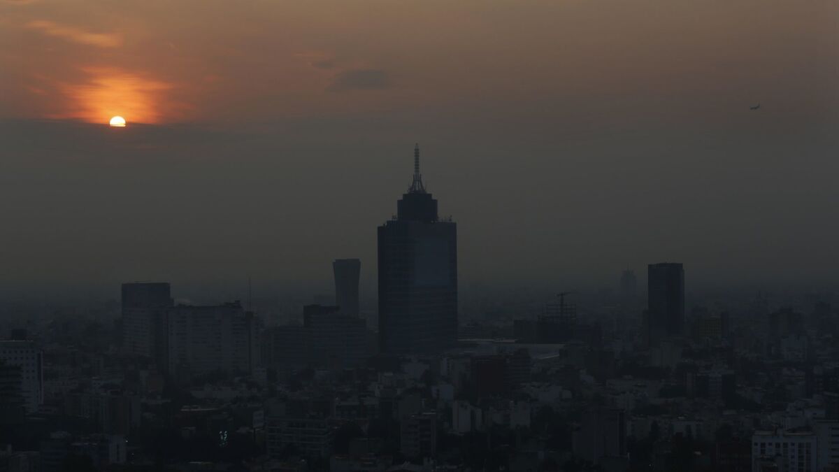Smog blankets the skyline of Mexico City, where schools have been closed and outdoor events, including professional soccer games, have been canceled because of the poor air quality.