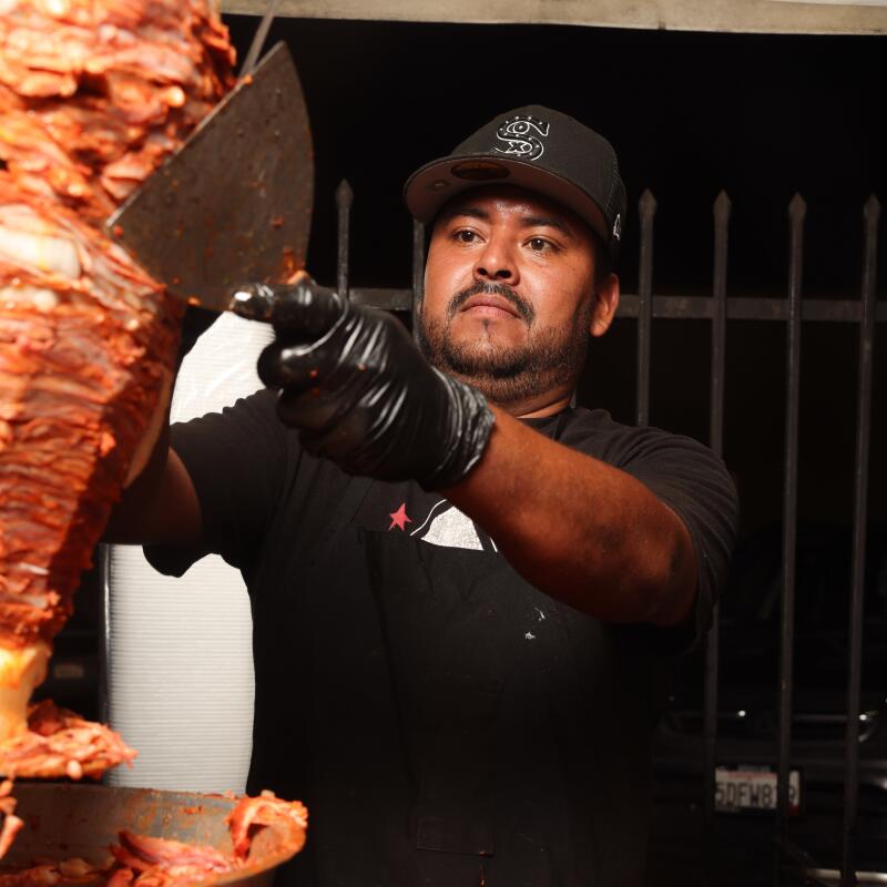 Juan cuts carne al pastor at Tacos Los 2 Poblanos.