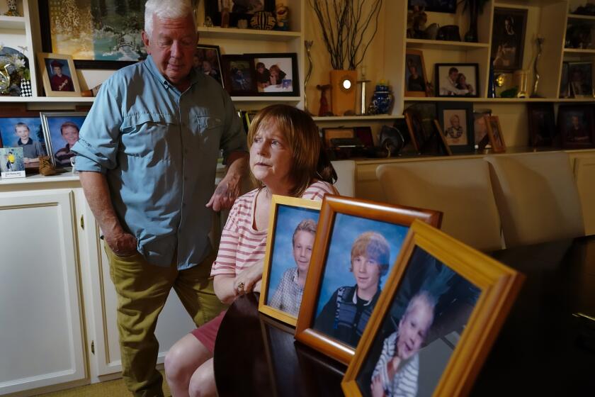 El Cajon, CA - April 25: At their home on Monday, April 25, 2022 in El Cajon, CA., Bruce and Melinda Wollitz sat next to several family photos of their son Marshall from when he was a young child. (Nelvin C. Cepeda / The San Diego Union-Tribune)