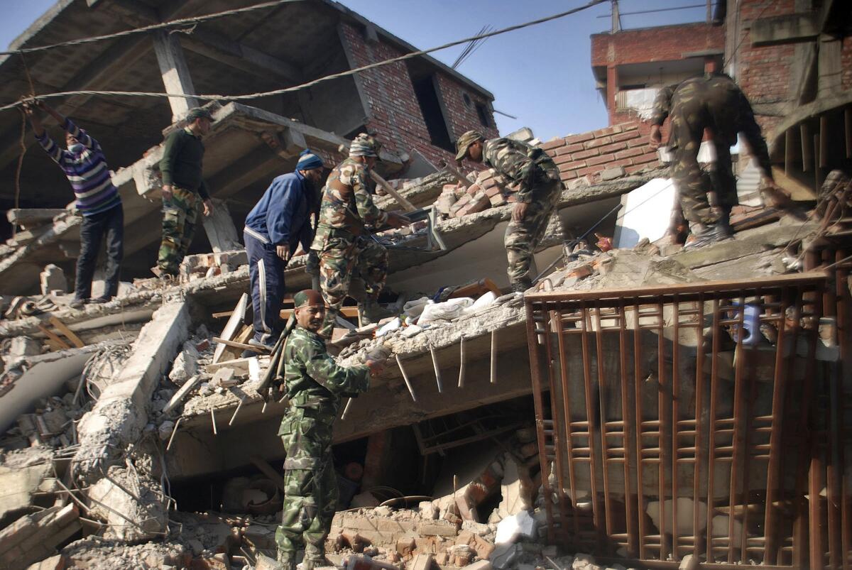 Soldiers and locals remove debris from a damaged building after an earthquake in Imphal, India, on Jan. 4.