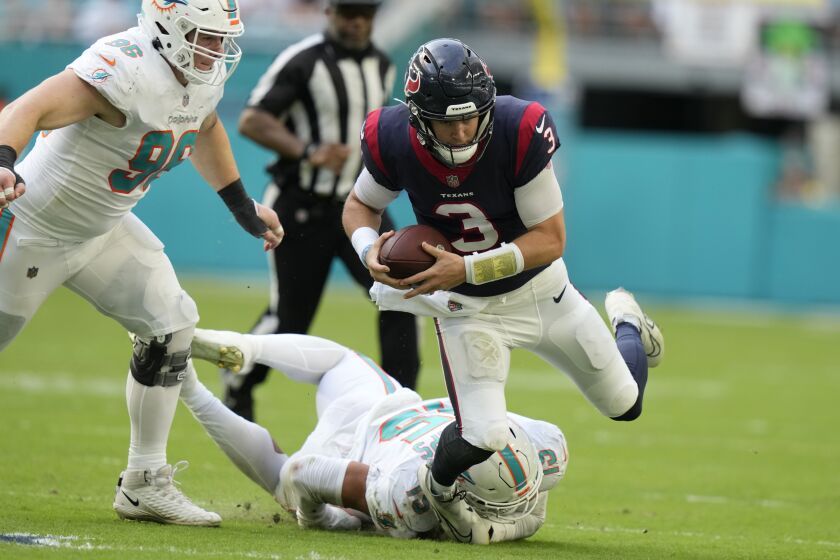 Miami Dolphins linebacker Jaelan Phillips (15) grabs Houston Texans quarterback Kyle Allen (3) during the second half of an NFL football game, Sunday, Nov. 27, 2022, in Miami Gardens, Fla. (AP Photo/Lynne Sladky)