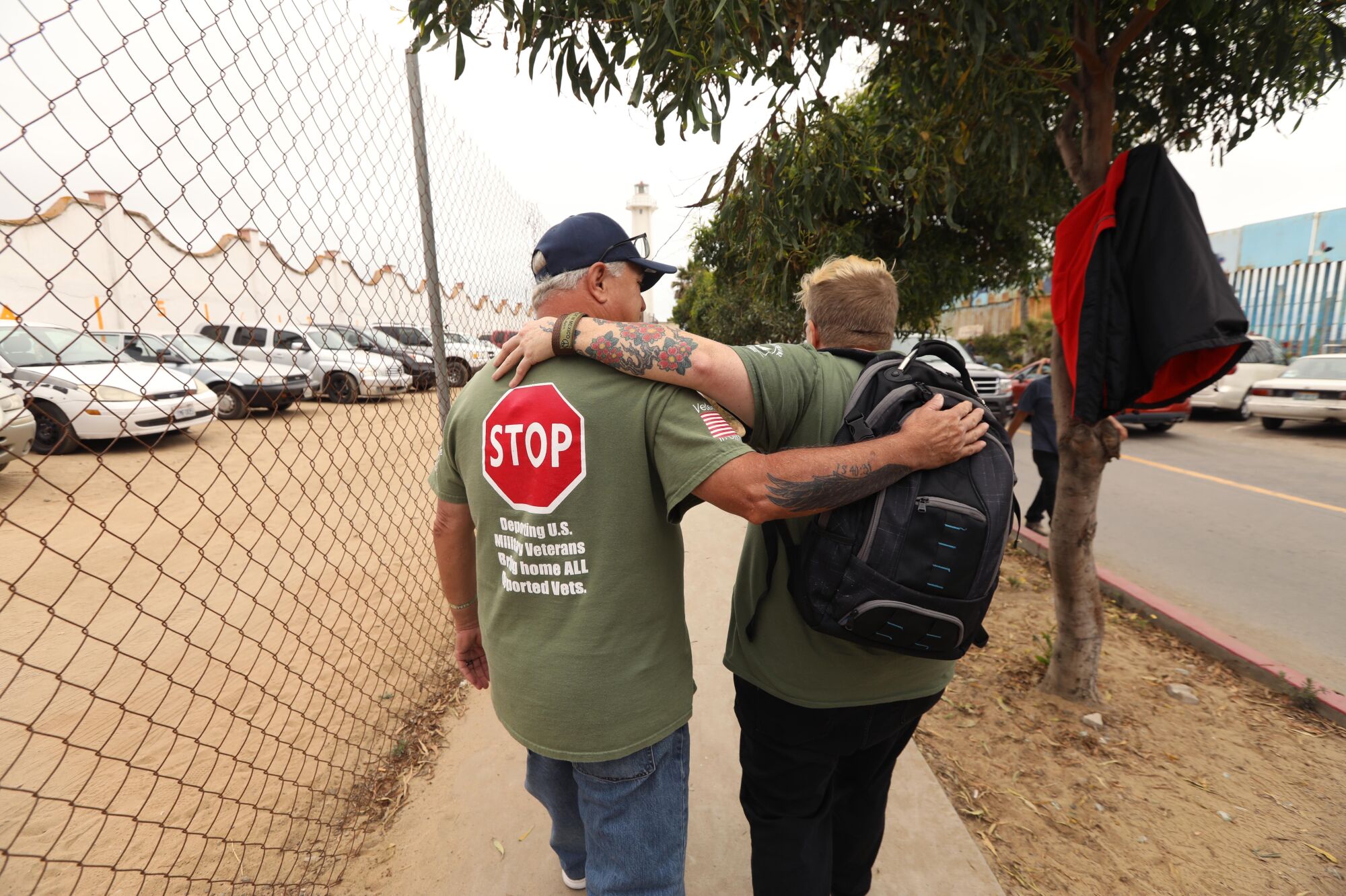 Jenn Budd, right, and deported U.S. veteran Robert Vivar, 63, walk with their arms around each other
