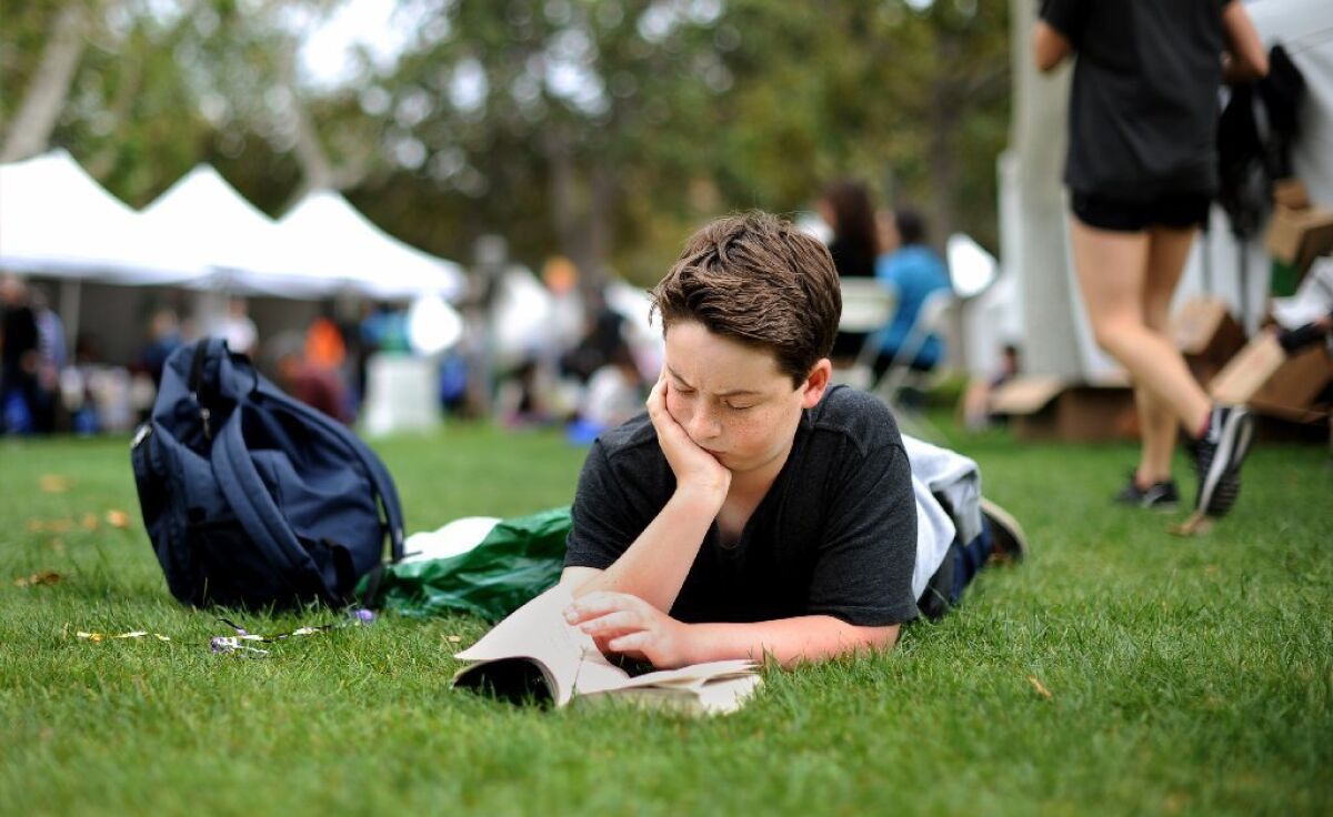Jasper Joseph, 13, of Santa Monica, dives into a book at the Los Angeles Times Festival of Books at USC on Sunday.