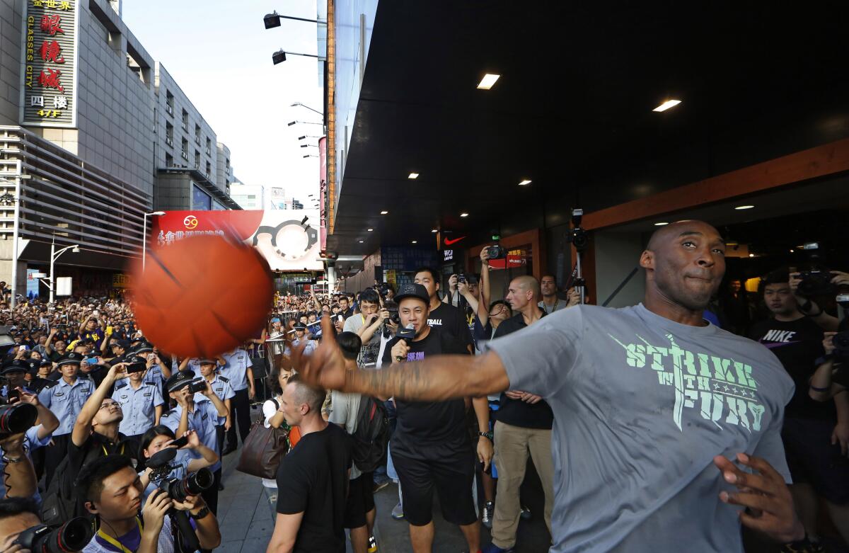  Kobe Bryant throws a ball to his fans during a promotional event in Shenzhen, China.