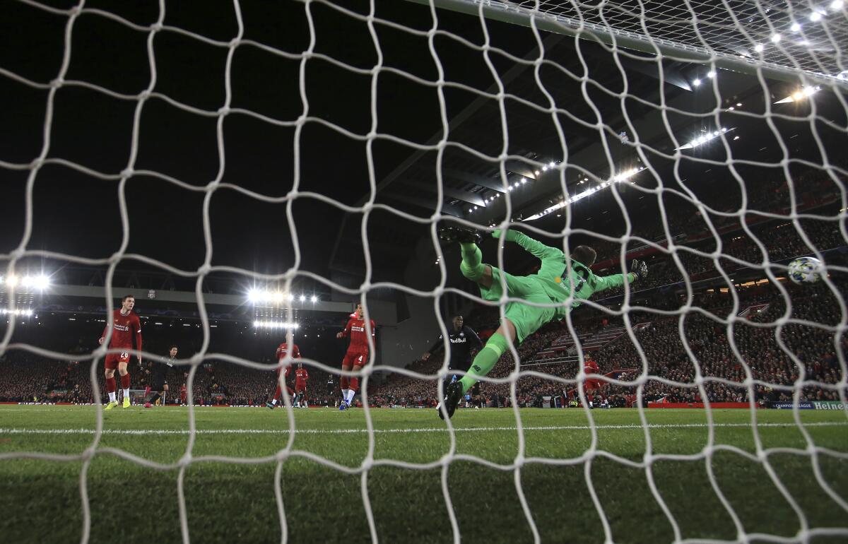 Salzburg's Takumi Minamino, second left, scores his side's second goal during the Champions League group E soccer match between Liverpool and Red Bull Salzburg at Anfield stadium in Liverpool, England, Wednesday, Oct. 2, 2019. (AP Photo/Jon Super)