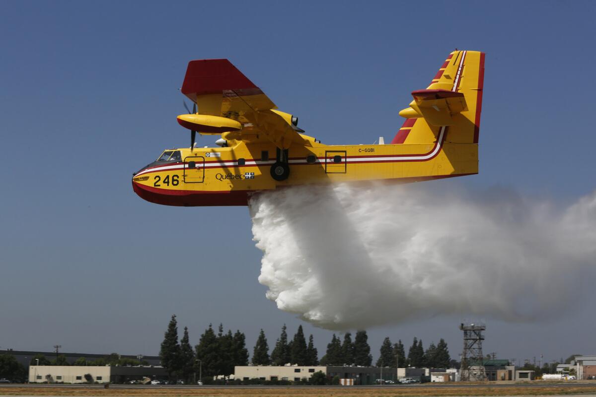 "Super scooper" Quebec 1 makes a water drop on the grass next to the runway at the Van Nuys Airport on Wednesday.