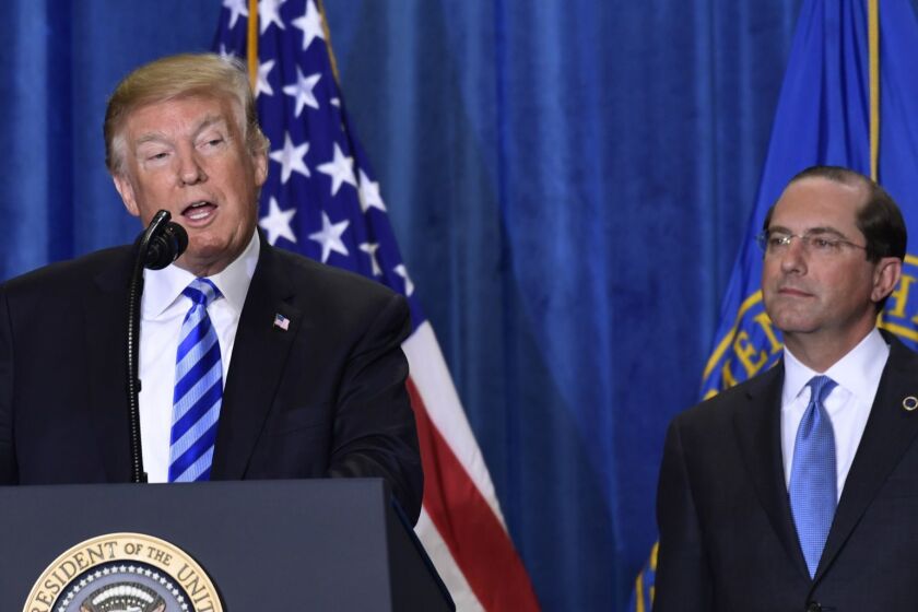 President Donald Trump, left, standing with Health and Human Services Secretary Alex Azar, right, talks about drug prices during a visit to the Department of Health and Human Services in Washington, Thursday, Oct. 25, 2018. (AP Photo/Susan Walsh)