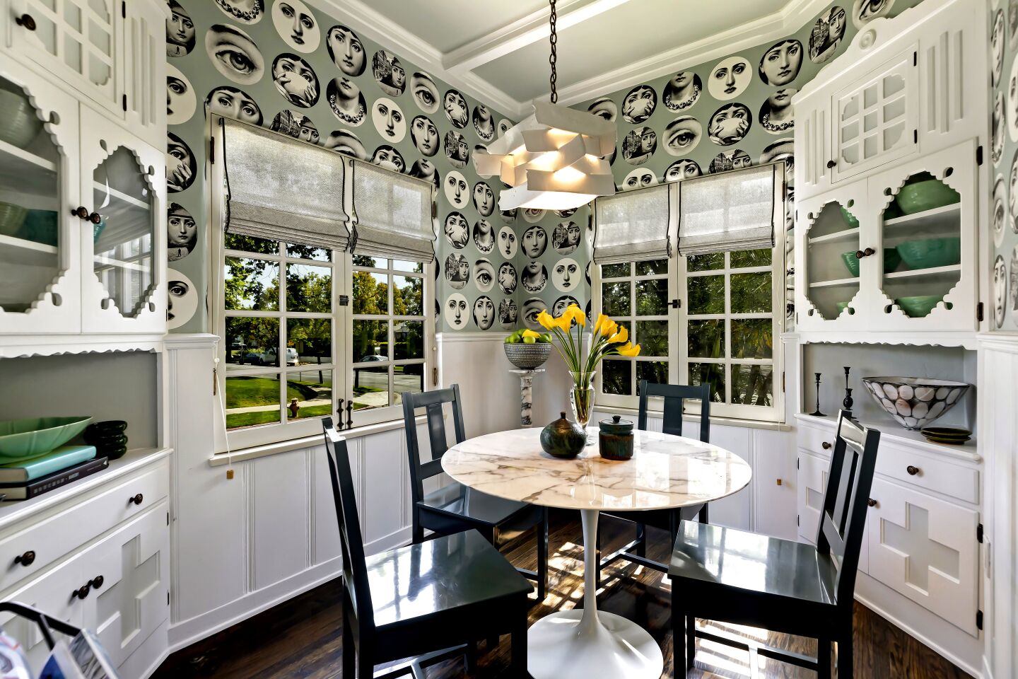 A breakfast room with striking pop art-style wallpaper and white cabinetry