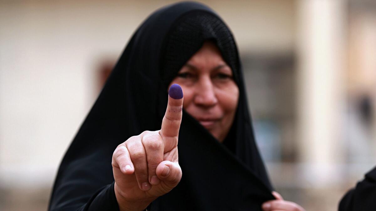 An Iraqi woman shows her ink-stained finger after casting her vote in the country's parliamentary elections in Ramadi, Iraq, on May 12.