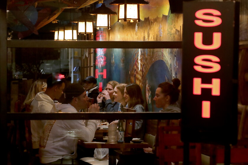 California logs record-breaking week of COVID-19
vaccinations 3 LONG BEACH, CALIF. - MAR. 15, 2021. Customers dine inside a sushi restaurant in Long Beach on Monday night, Mar. 15, 2021. Under L.A. County reopening guidelines, restaurants can open indoors at 25% capacity but must maintain eight feet of distance between tables. Indoor malls can operate at 50% capacity. (Luis Sinco/Los Angeles Times)