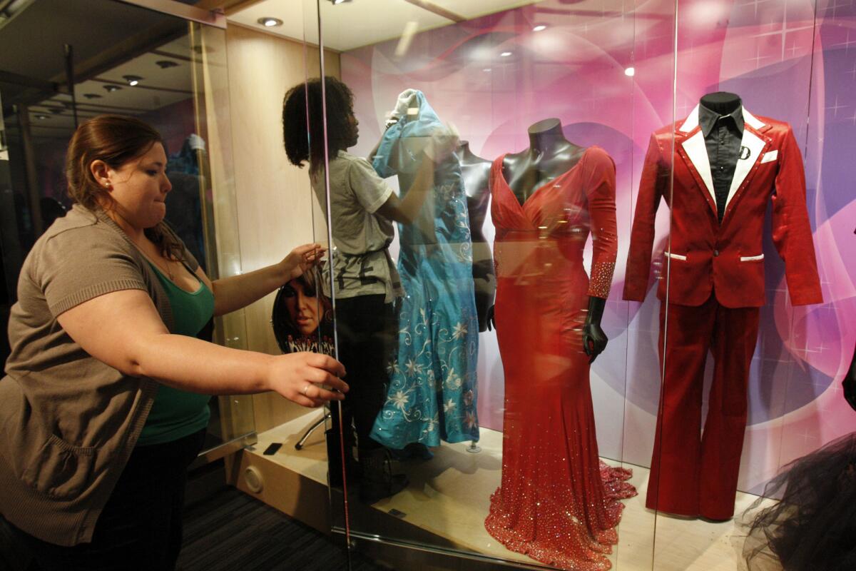 Athena Jaharis, left, assistant registrar, and Nwaka Onwusa, assistant curator, set up Jenni Rivera dresses, mementos and other artifacts in the Grammy Museum.