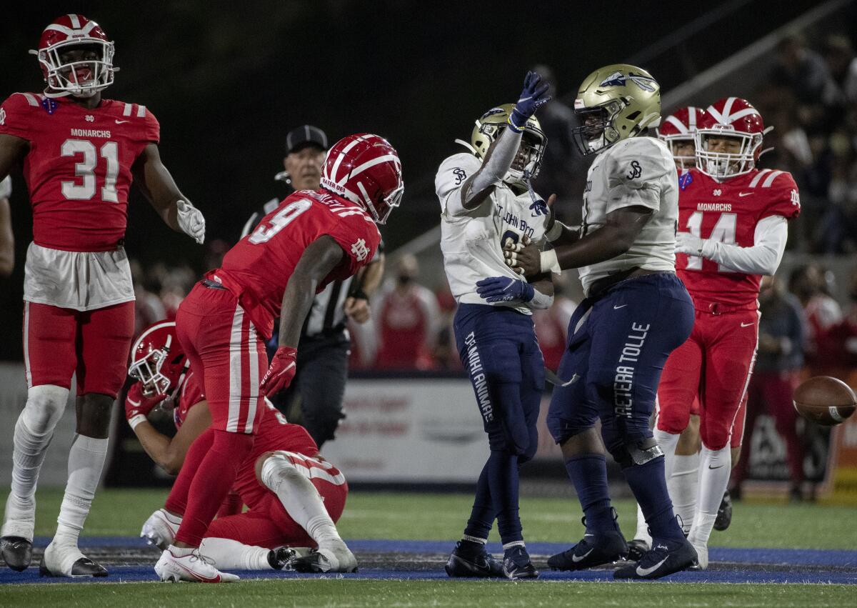 St. John Bosco running back Jabari Bates celebrates with teammate Edward Riley near Mater Dei players on the field.