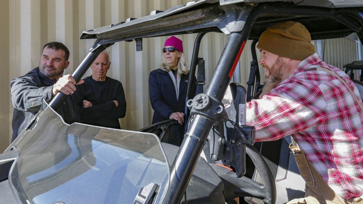 Ben Stone, right, explains the features of an off-road vehicle to Daniel Noll, left, Mike Huhn and Maura Sughrue.