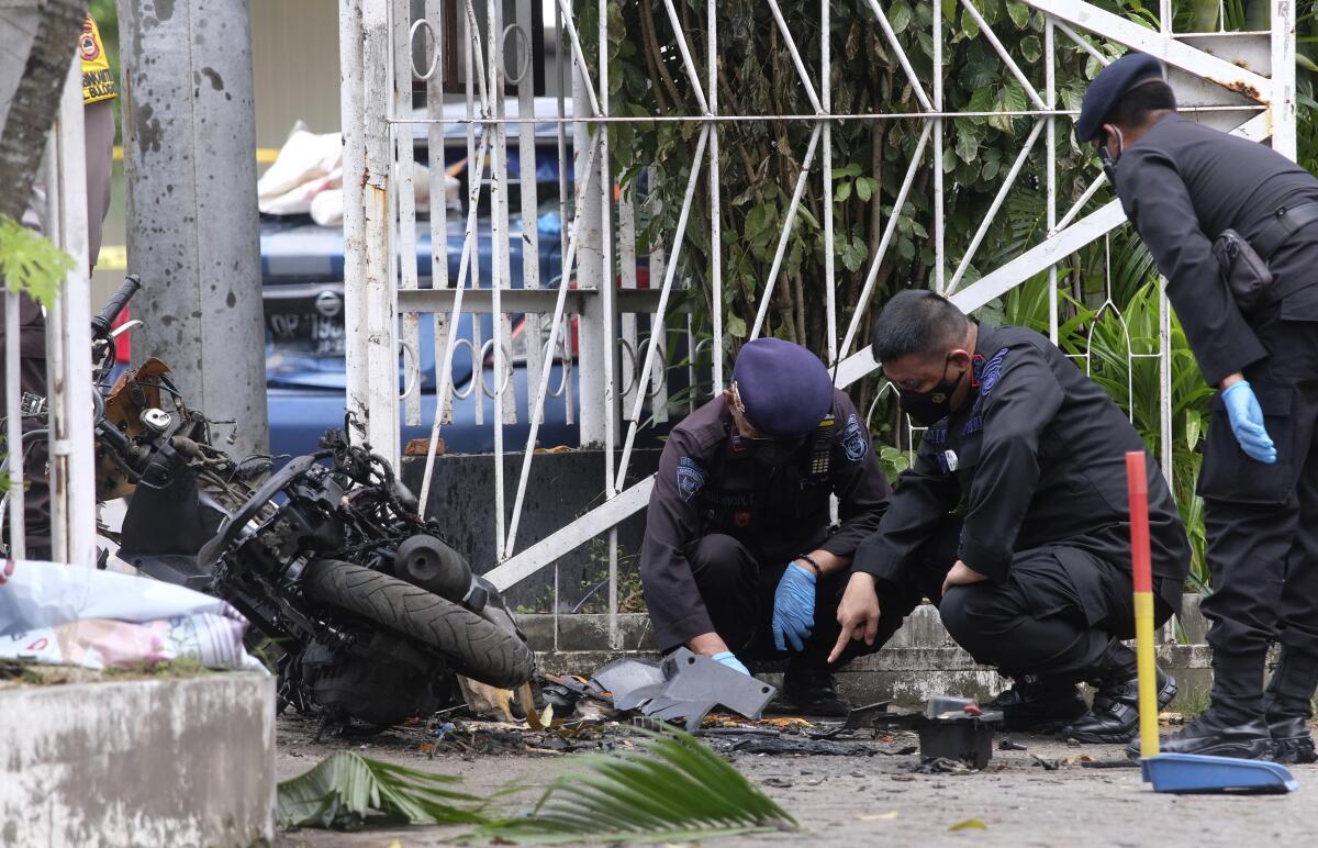 Bomb squad officers inspect wreckage of attack